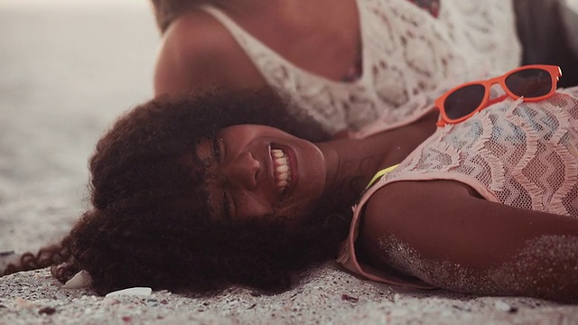 非洲女孩和她的朋友在海滩上大笑和开玩笑视频素材