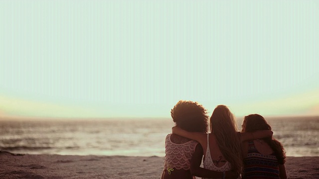 女朋友们一起坐在沙滩上看日落视频素材