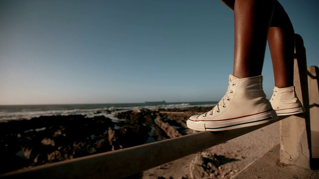 少年穿着运动鞋站在海边视频下载