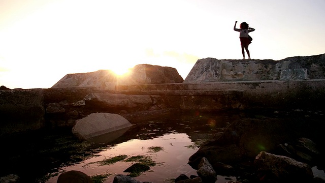 欢乐的潮人青少年在岩石上跳舞，兴奋地伸出胳膊视频素材