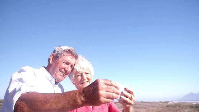 一对笑着用手机自拍的退休老夫妇视频下载