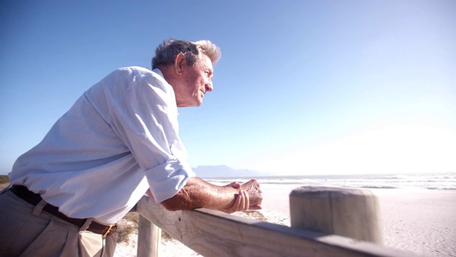 一位退休老人在海滩上的全景图视频下载