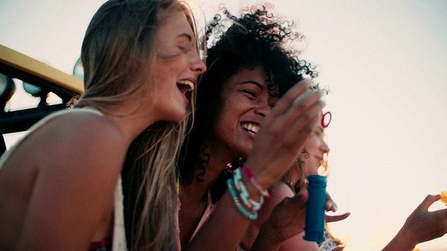 非洲女孩和朋友们在海滩上吹泡泡视频素材