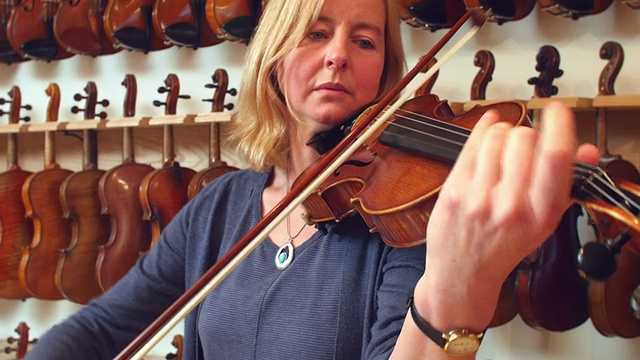 顾客在音乐商店试用小提琴视频素材