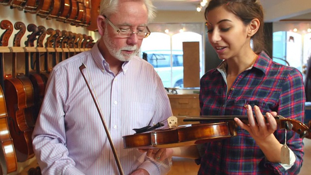 售货员建议顾客购买小提琴视频素材
