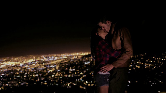 以城市灯光为背景的情侣接吻视频素材