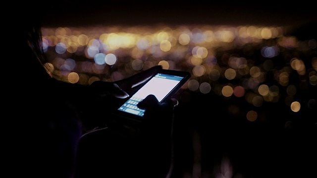 晚上在户外用手机发送短信的人视频素材