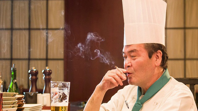 满意的日本厨师坐在厨房视频素材