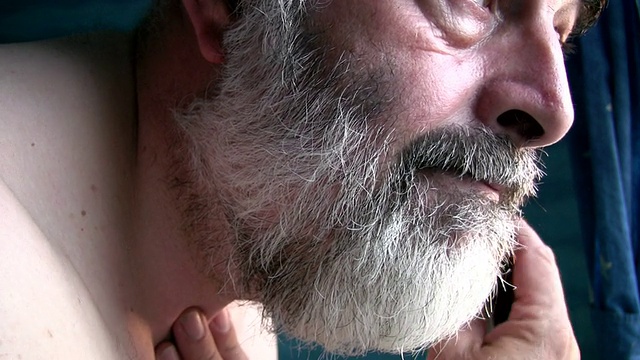 胡子花白的男人正在用电动修理工修胡子视频下载