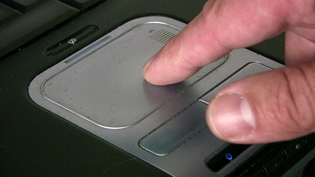 男性的手在用脏兮兮的笔记本电脑触控板。视频下载
