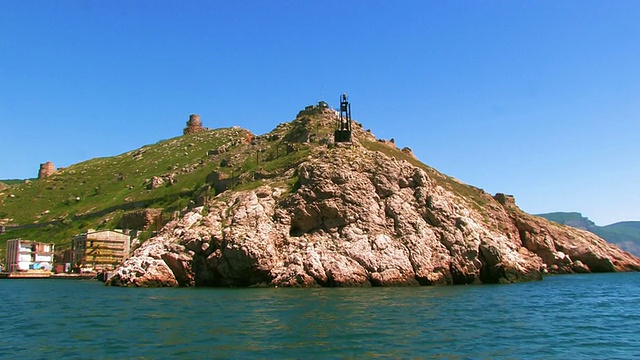 岩石海岸与灯塔和古老的要塞，从海上看。视频下载