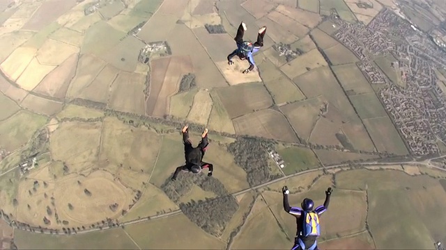 三名跳伞运动员在自由落体时做队形动作视频素材