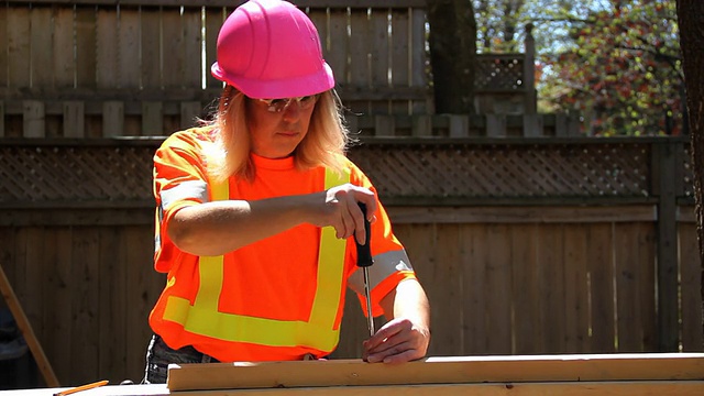 戴粉色安全帽的女人用螺丝刀视频下载