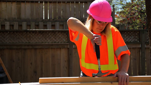 戴粉色安全帽的女人用锤子视频下载