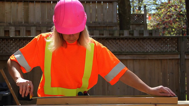 戴粉色安全帽的女人测量木头视频下载