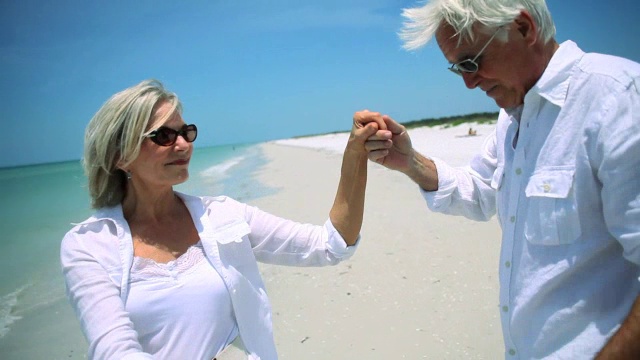 一对迷人的老年情侣在海滩上跳舞视频素材