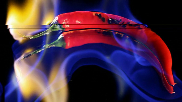 燃烧的辣椒与火焰在黑色的镜子背景视频素材