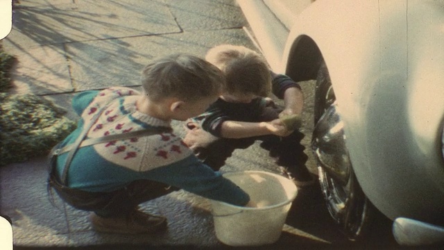 小男孩洗爸爸的车(老式8毫米胶卷)视频素材