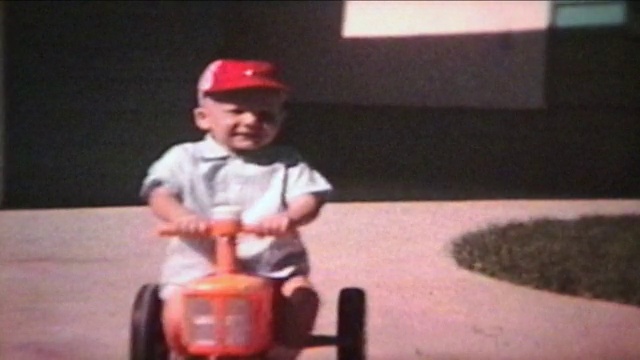 男孩在外面骑拖拉机(1964年-老式8毫米胶卷)视频素材