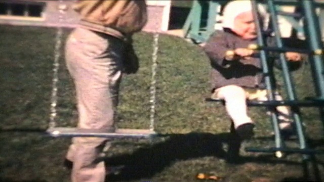 爸爸推着秋千上的小男孩(1963 -复古8毫米)视频素材