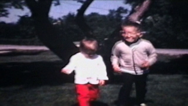 兄妹在户外玩耍(1968年8毫米胶片)视频素材