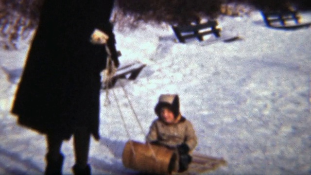和妈妈一起拉雪橇的女孩(1942年8毫米胶片)视频素材