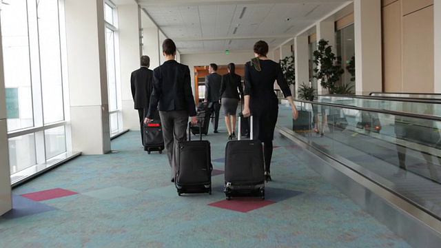 商务人士带着行李穿过机场视频素材