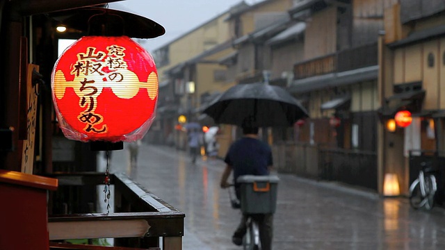 一名骑自行车的人在京都祗园的街道上骑行视频下载