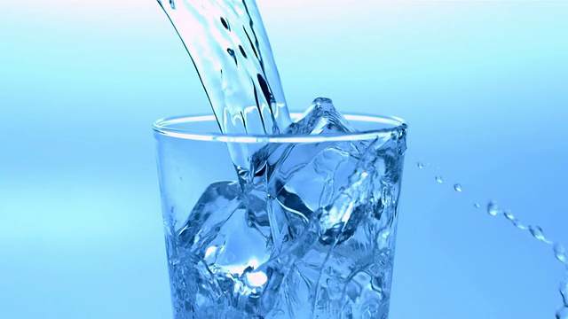 把水倒在装满冰块的杯子上视频素材