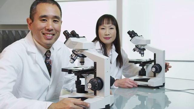 两个科学家用显微镜的肖像视频素材