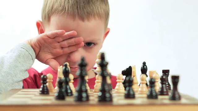 野心勃勃的小男孩在下棋。视频下载