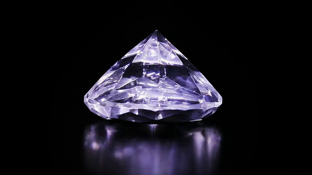一个巨大的钻石石头旋转在黑暗的背景视频下载