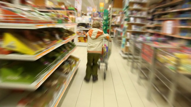 男孩推着购物车在超市里跑视频下载