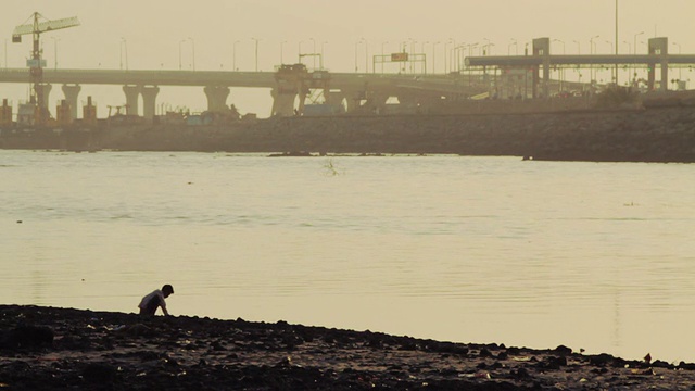 坐在孟买河岸上的孩子。视频素材