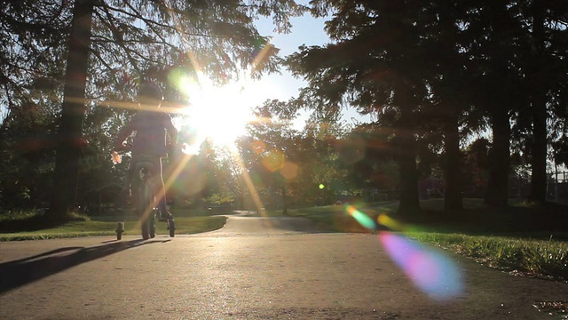 小女孩骑着粉红色的自行车奔向夕阳视频素材