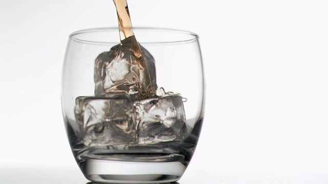 威士忌倒入装有冰块的玻璃杯中视频素材