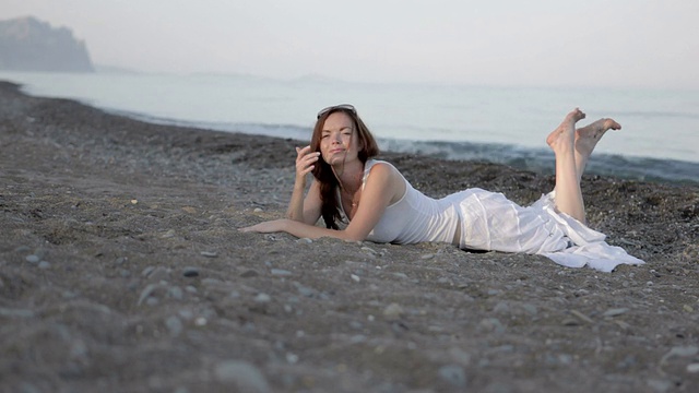 美丽的女人躺在沙滩上视频素材