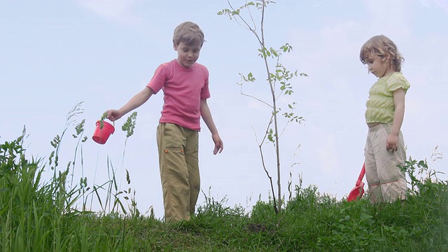 男孩和女孩拿着铲子谈论植物视频下载