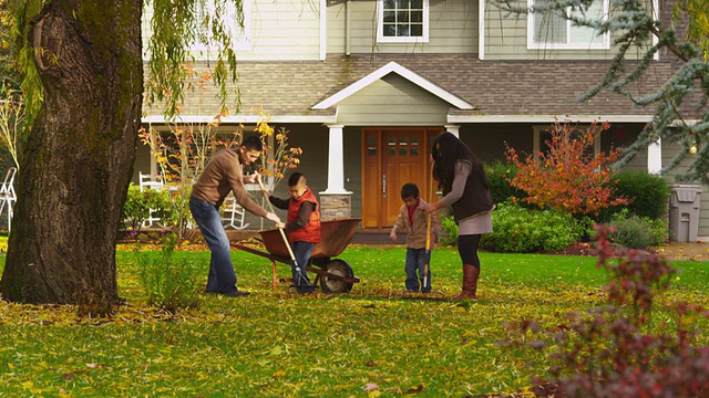 秋天一家人在户外耙树叶视频素材