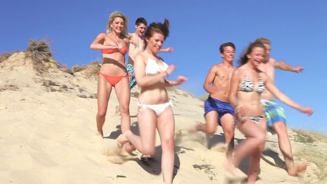 一群青少年跑下沙丘视频素材