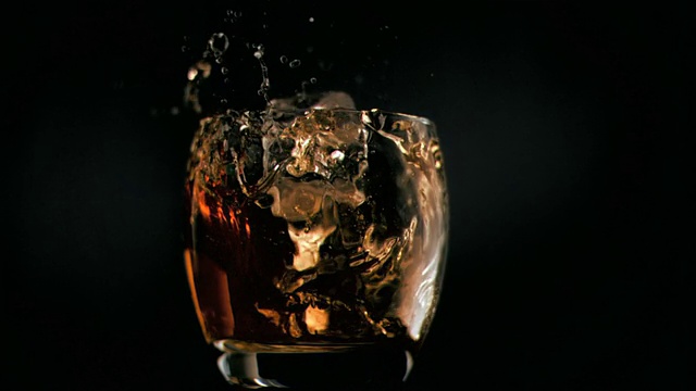 威士忌里的冰块以超慢的动作落下视频素材