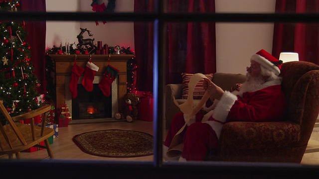圣诞老人坐在壁炉旁看名单视频素材