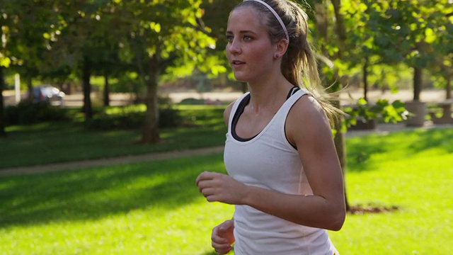 健康的年轻女子在公园慢跑视频素材