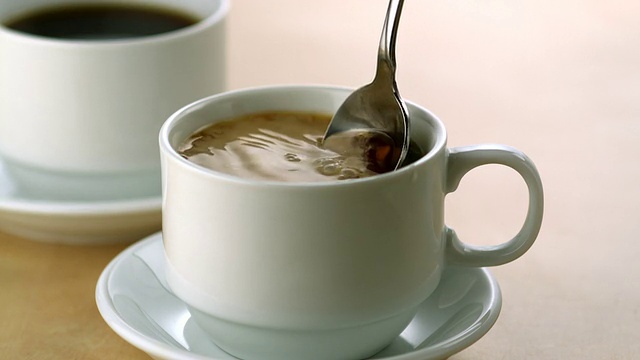 在咖啡里搅拌牛奶，慢动作视频素材