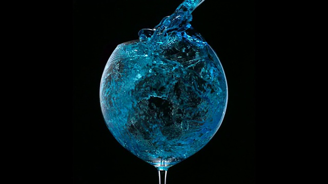 将蓝色的水倒入玻璃杯，慢动作视频下载