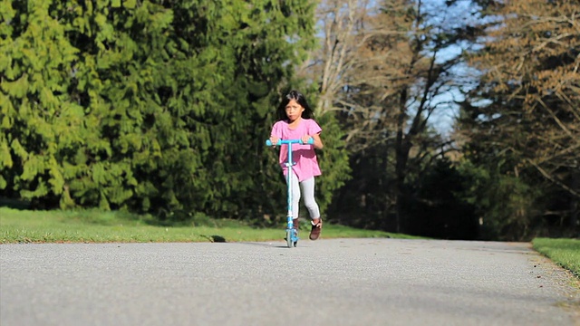 亚洲小女孩努力骑她的新滑板车视频素材