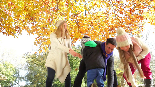 一家人在秋园里抛树叶视频素材