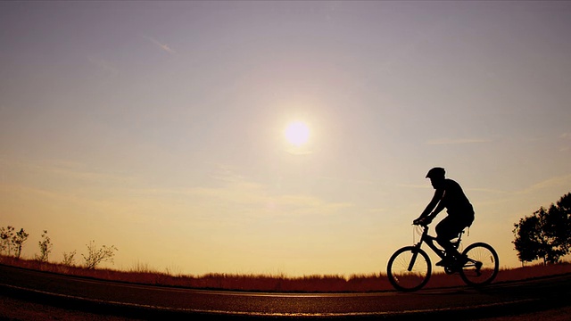 剪影早晨健身自行车在道路上视频下载
