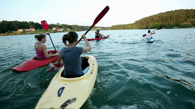 HD CRANE:年轻人在远离镜头的湖中划独木舟视频素材