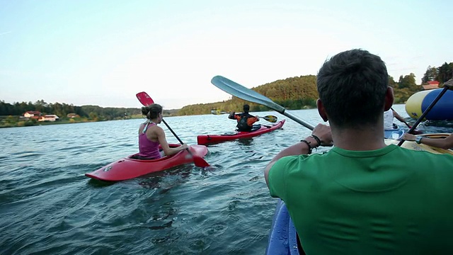 一群年轻人在湖中划独木舟视频素材